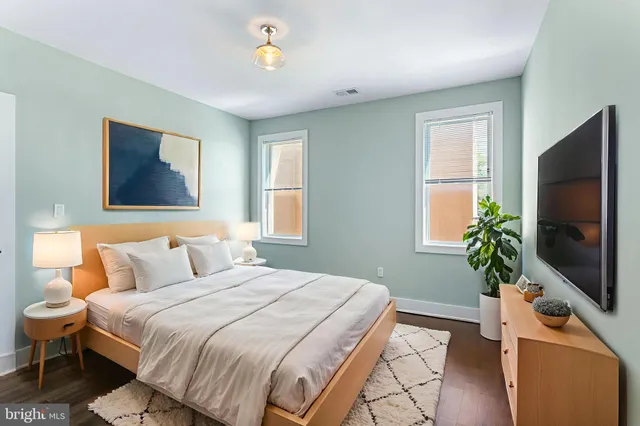 a bedroom with a bed and a flat screen tv