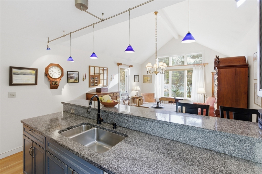 18 Quail Run, Unit 18 Acton, MA 01720 - Photo 8 of 23 a kitchen with granite countertop a sink a stove and a wooden floor