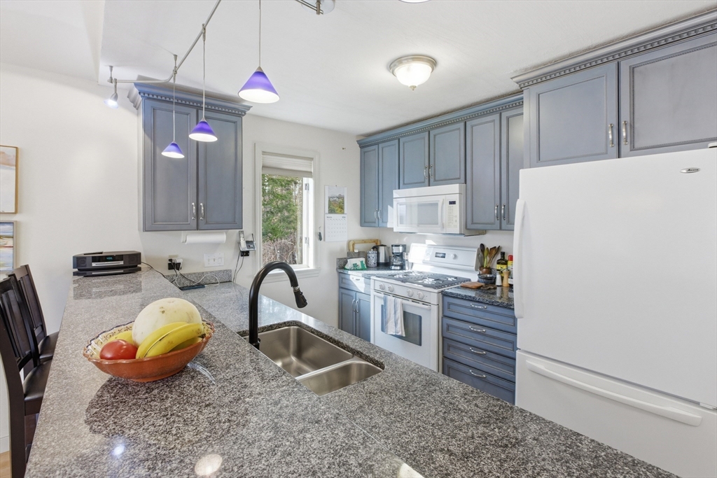 18 Quail Run, Unit 18 Acton, MA 01720 - Photo 10 of 23 a kitchen with sink refrigerator and cabinets