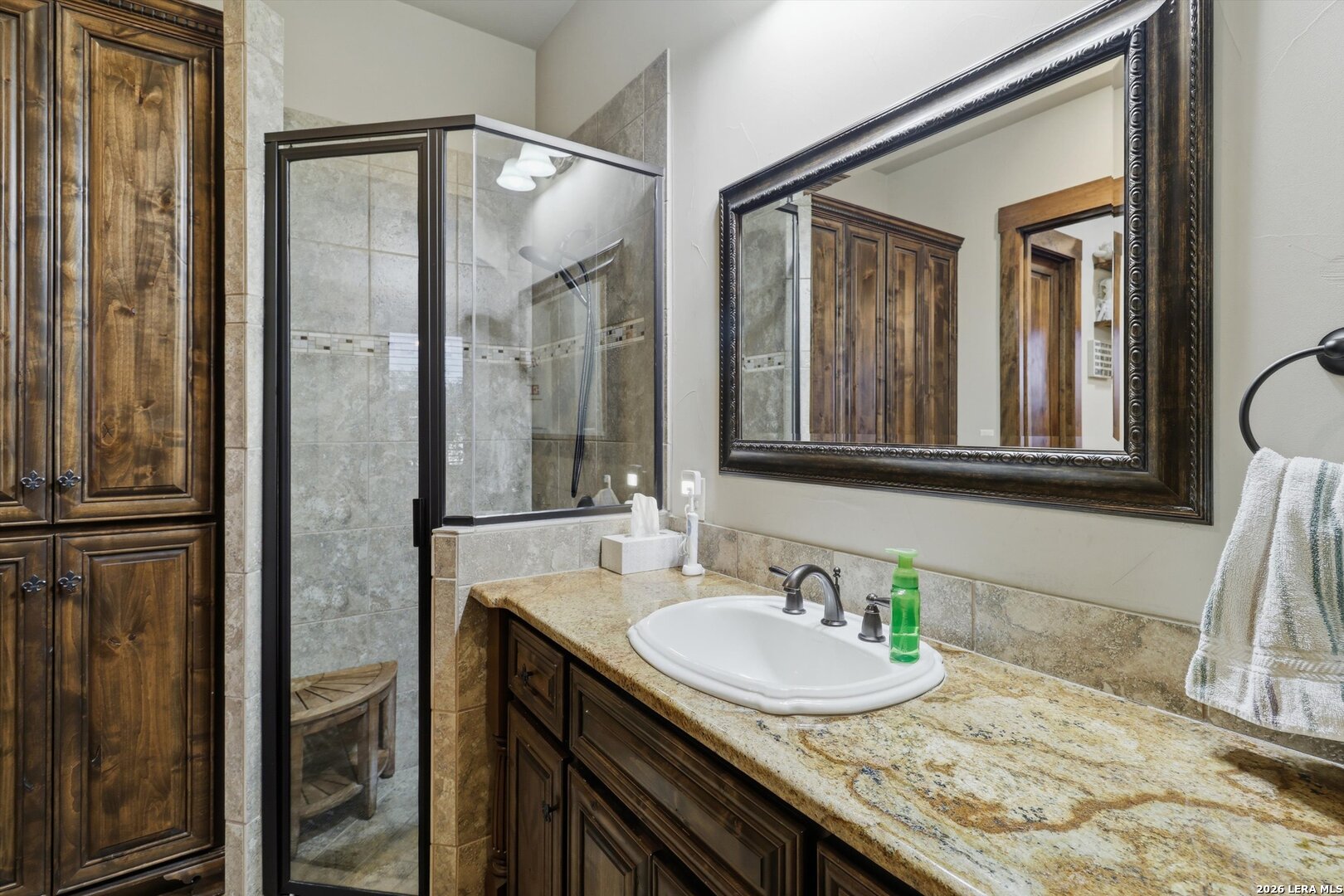 439 Mystic Parkway Spring Branch, TX 78070 - Photo 17 of 39 a bathroom with a granite countertop sink a mirror and a shower