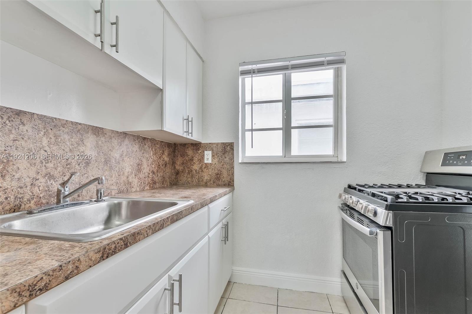 6921 Rue Vendome, Unit 1 Miami Beach, FL 33141 - Photo 6 of 27 a kitchen that has a sink and a stove