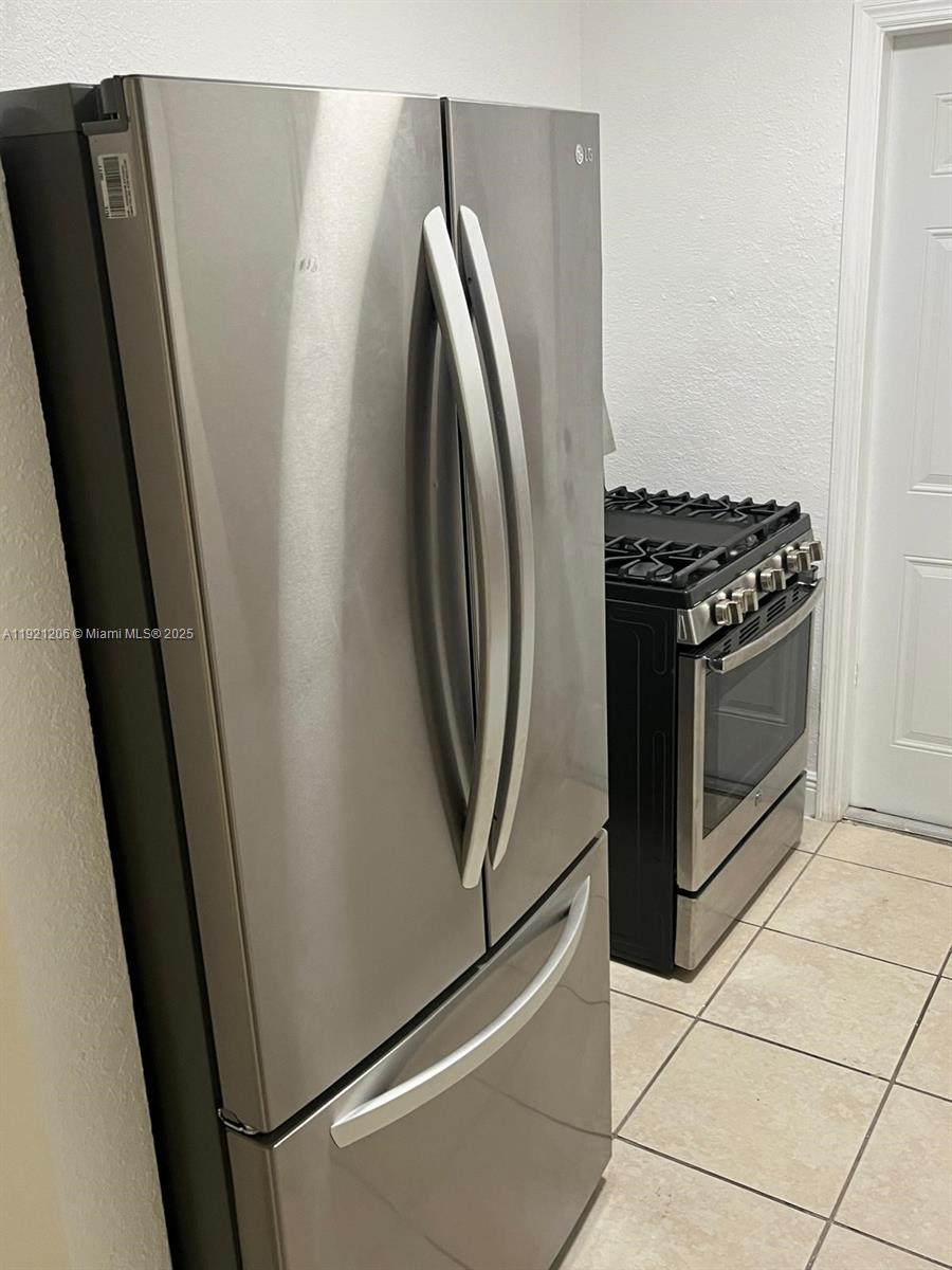6921 Rue Vendome, Unit 1 Miami Beach, FL 33141 - Photo 7 of 23 a view of a kitchen with fridge and wooden floor