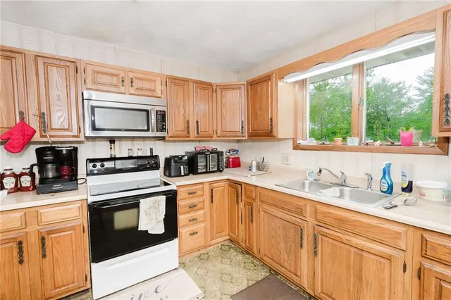 a kitchen with granite countertop a stove sink microwave and cabinets