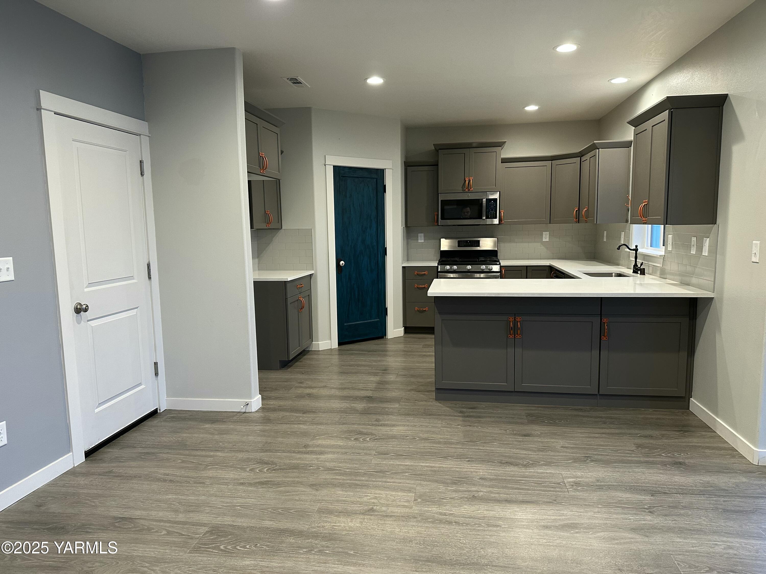519 LaCoursiere Street Moxee, WA 98936 - Photo 17 of 28 a kitchen with kitchen island stainless steel appliances a sink refrigerator stove and microwave
