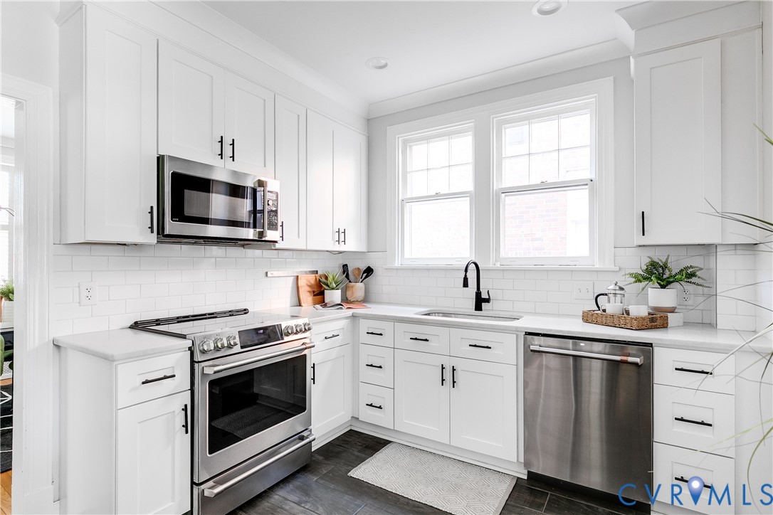 4617 Sylvan Road Richmond, VA 23225 - Photo 11 of 33 a kitchen with white cabinets and white appliances