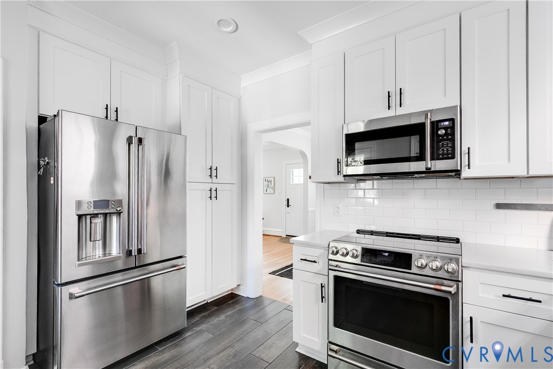 4617 Sylvan Road Richmond, VA 23225 - Photo 12 of 33 a kitchen with cabinets stainless steel appliances and wooden floor