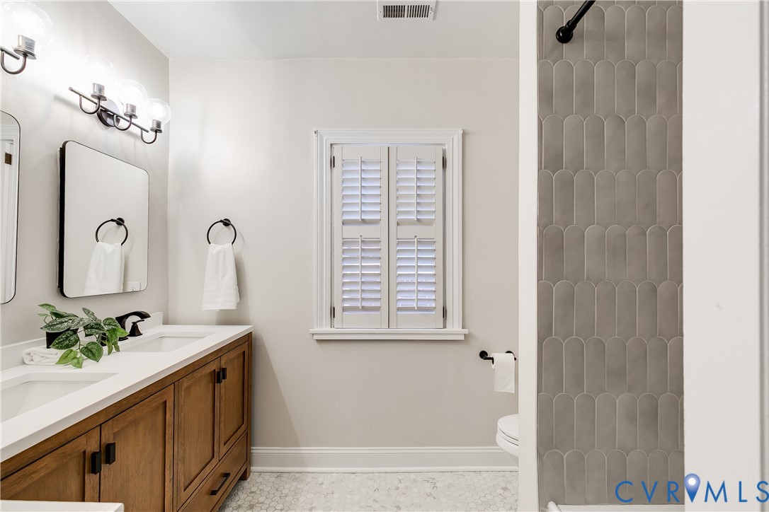 4617 Sylvan Road Richmond, VA 23225 - Photo 18 of 33 a bathroom with a sink a mirror and a window