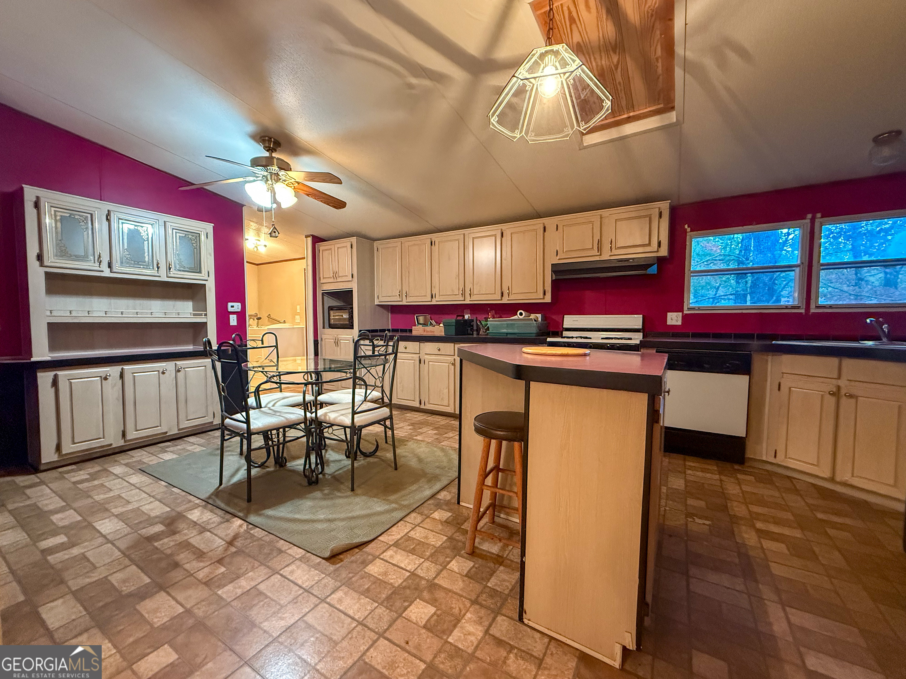 431 Paradise Valley Road Cleveland, GA 30528 - Photo 7 of 27 a kitchen with stainless steel appliances granite countertop a stove top oven a dining table and chairs with wooden floor