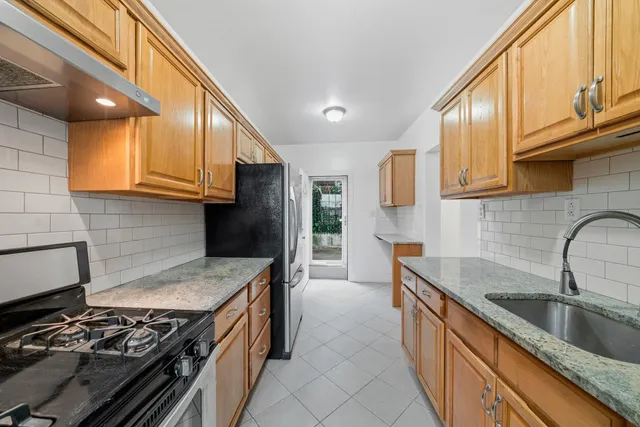 a kitchen with granite countertop a refrigerator and a sink