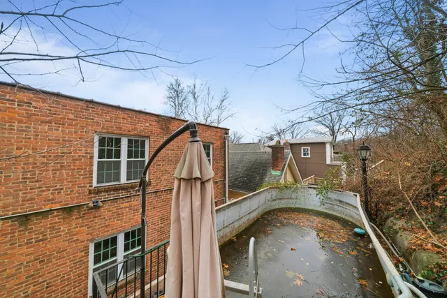 a view of a brick house with stairs and wooden fence