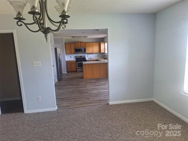 a view of kitchen with stainless steel appliances granite countertop a stove and a sink