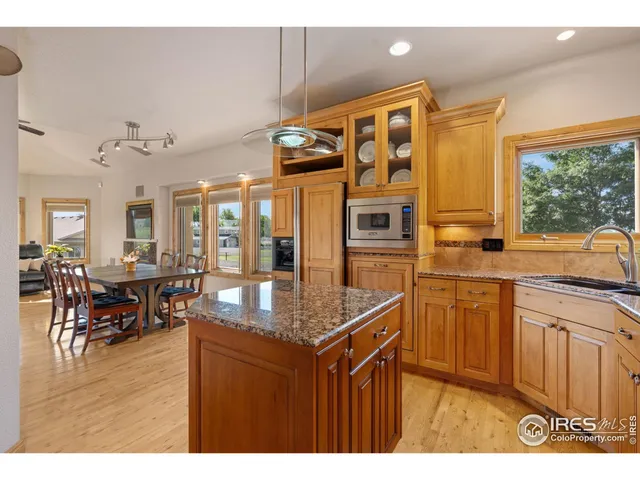 a dining hall with stainless steel appliances granite countertop a granite counter tops and a view of living room
