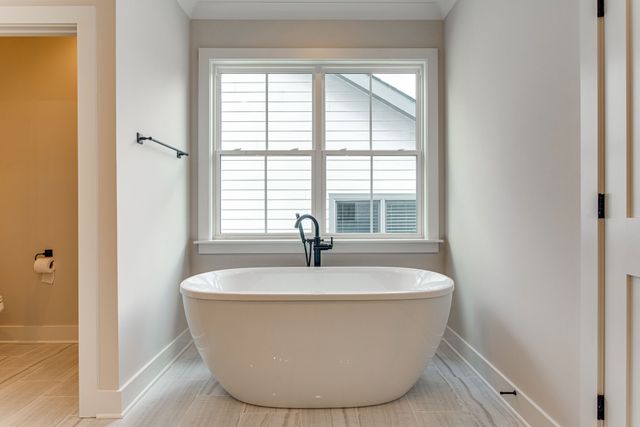 a white bath tub sitting in a bathroom next to a window