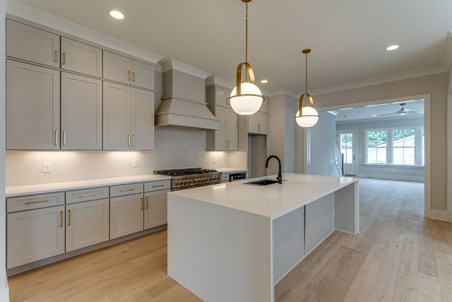 a kitchen with a sink cabinets and wooden floor
