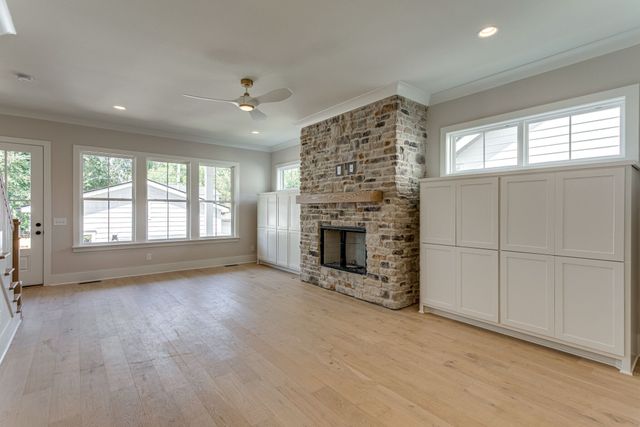 an empty room with windows and fireplace
