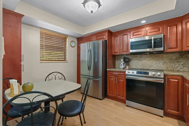 a kitchen with stainless steel appliances granite countertop a refrigerator a sink a stove and island