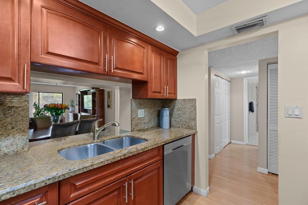 16051 Blatt Boulevard, Unit 212 Weston, FL 33326 - Photo 18 of 52 a kitchen with granite countertop a sink and cabinets