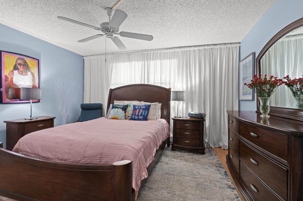 16051 Blatt Boulevard, Unit 212 Weston, FL 33326 - Photo 21 of 52 a bedroom with a bed and a chandelier