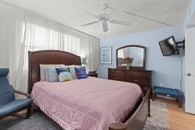 a bedroom with a bed a flat screen tv and a window