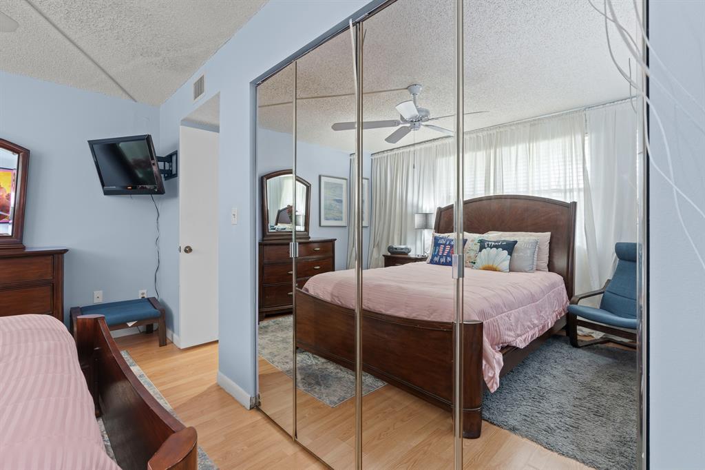 16051 Blatt Boulevard, Unit 212 Weston, FL 33326 - Photo 24 of 52 a bedroom with a bed a flat screen tv and a window