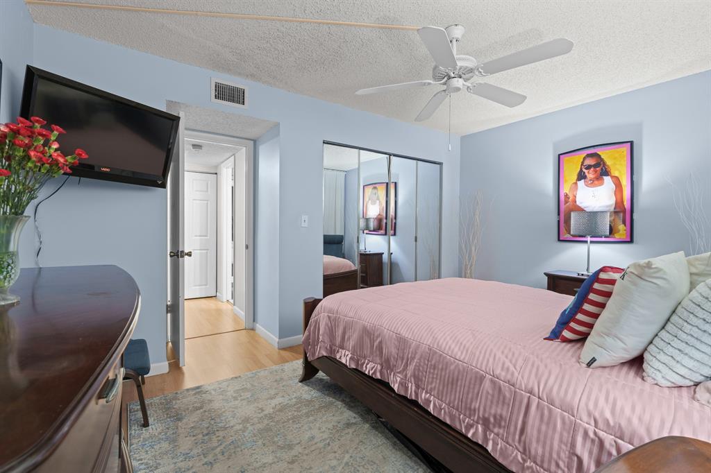 16051 Blatt Boulevard, Unit 212 Weston, FL 33326 - Photo 25 of 52 a bedroom with a bed and a chair with the potted plant