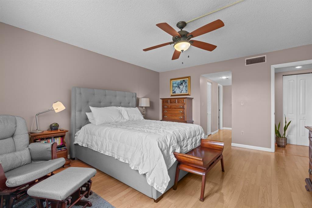 16051 Blatt Boulevard, Unit 212 Weston, FL 33326 - Photo 31 of 52 a bedroom with a bed and a chair