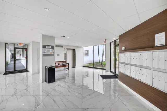 a view of an empty room with windows & view of bedroom