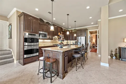 a kitchen with stainless steel appliances granite countertop a sink and a wooden cabinets