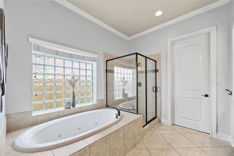 a spacious bathroom with a granite countertop double vanity sink a mirror and a bathtub