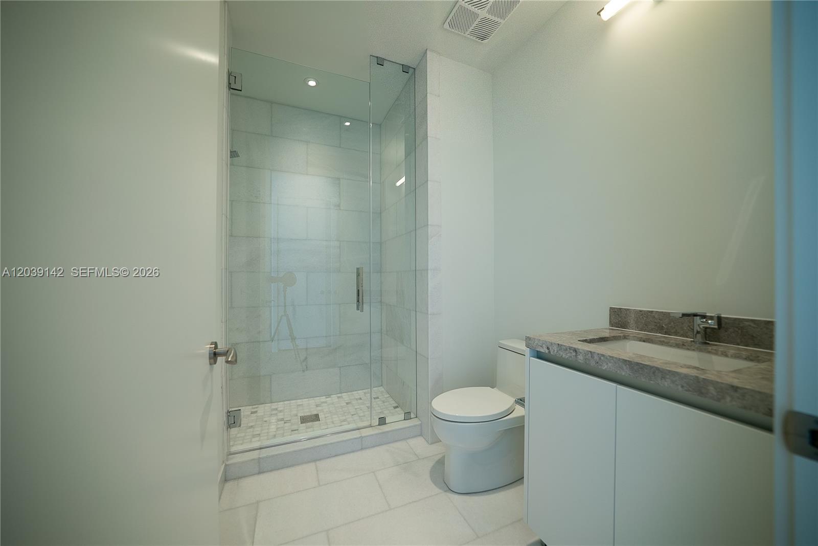 175 Southeast 25th Road, Unit 702 Miami, FL 33129 - Photo 21 of 30 a bathroom with a granite countertop sink a toilet and shower
