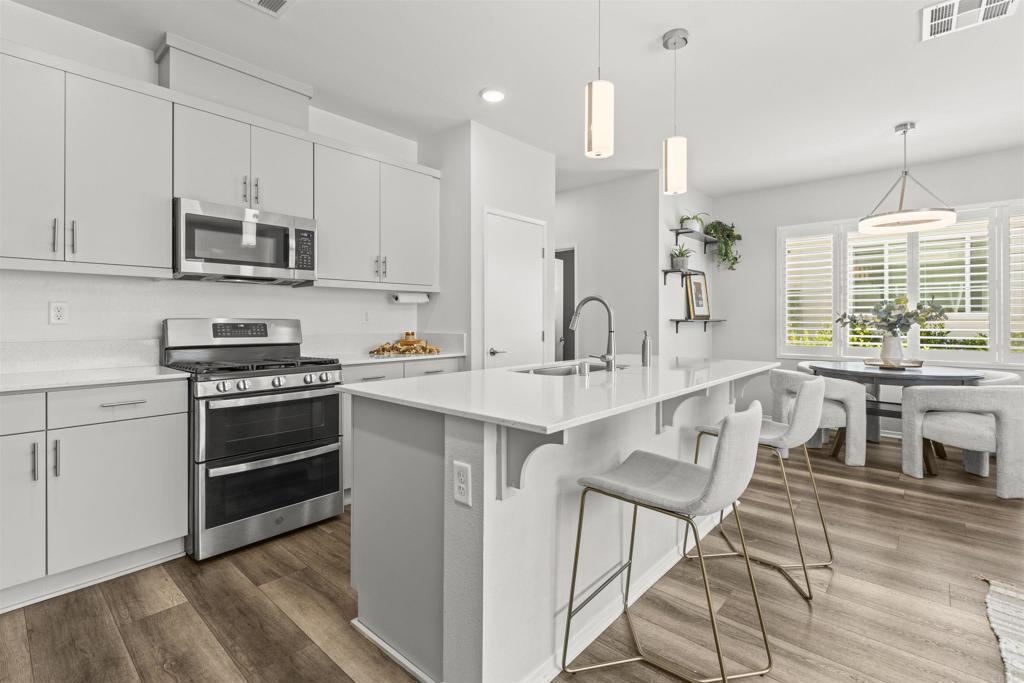323 Citrine Trail Fallbrook, CA 92028 - Photo 5 of 21 a kitchen with stainless steel appliances granite countertop a stove a sink dishwasher and a refrigerator with wooden floor