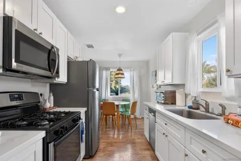 a kitchen with stainless steel appliances a stove sink microwave and cabinets