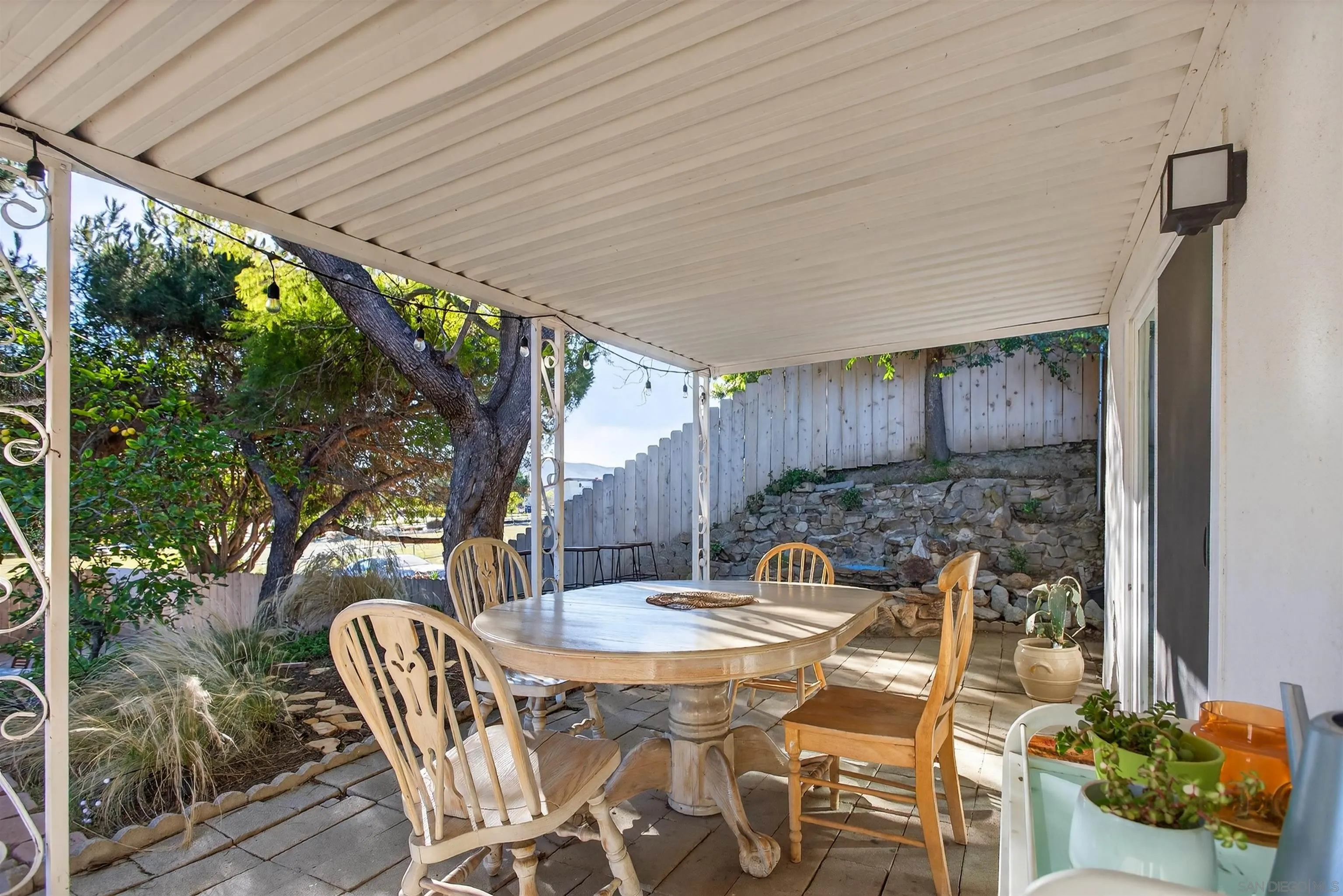 3548 De Leone Road San Marcos, CA 92069 - Photo 28 of 46 a view of a patio with table and chairs potted plants with floor to ceiling window and wooden floor