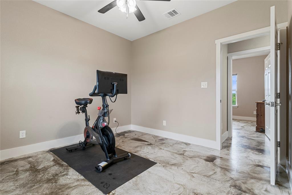 139 Kriston Lane Springtown, TX 76082 - Photo 19 of 39 Spacious room featuring neutral painted walls, white trim, a ceiling fan with light fixture, and unique patterned flooring