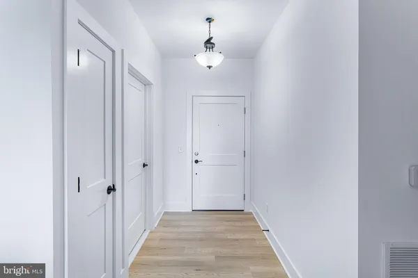 a view of a hallway with a chandelier fan