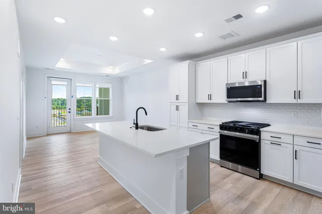 a kitchen with sink a stove and cabinets