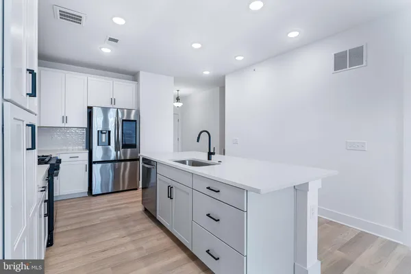 a kitchen with stainless steel appliances a refrigerator sink and cabinets