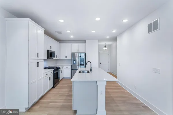 a large kitchen with stainless steel appliances lots of counter space and a sink