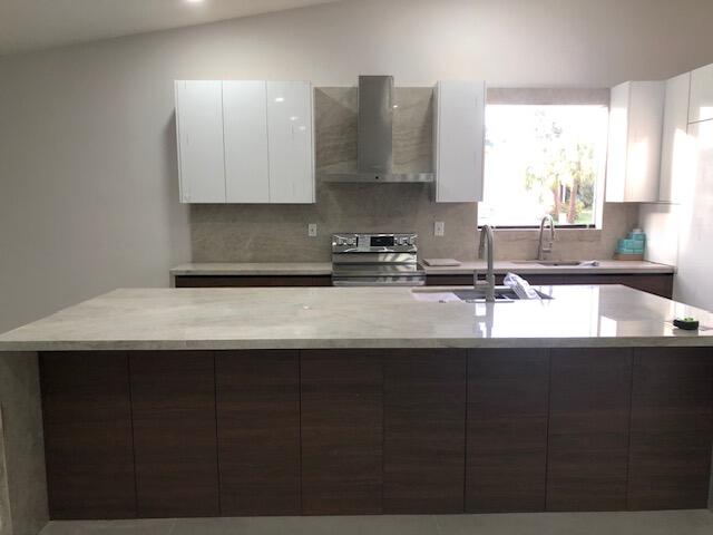22171 Hollyhock Trail Boca Raton, FL 33433 - Photo 3 of 24 a kitchen with a sink a stove and cabinets