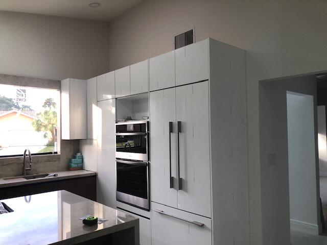 22171 Hollyhock Trail Boca Raton, FL 33433 - Photo 5 of 24 a kitchen with stainless steel appliances a refrigerator sink and stove