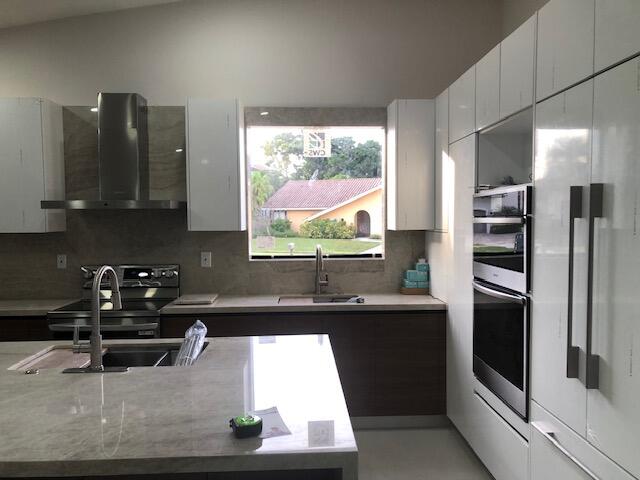 22171 Hollyhock Trail Boca Raton, FL 33433 - Photo 6 of 24 a kitchen with stainless steel appliances kitchen island granite countertop a refrigerator and a sink