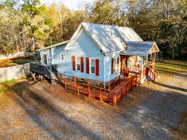 an aerial view of a house with a yard and wooden deck