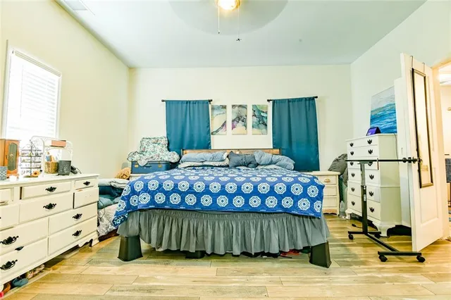 a bedroom with a bed a dresser and a large mirror