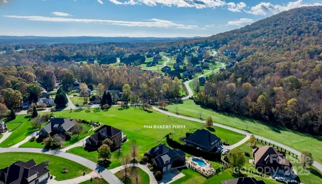 a yard with lots of green space and mountain view in back