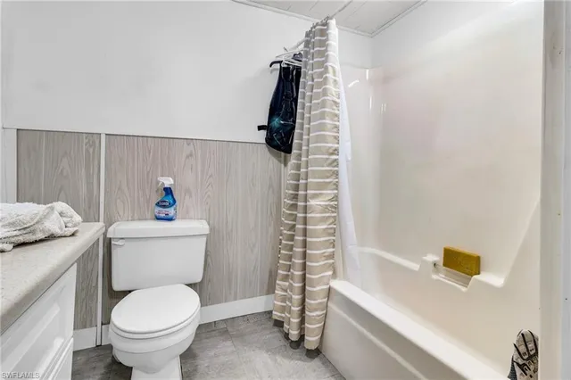 a white toilet sitting next to a bath tub