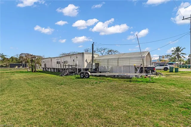 a view of a house with a big yard and a large tree