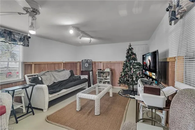 a living room with furniture a dining table and a potted plant