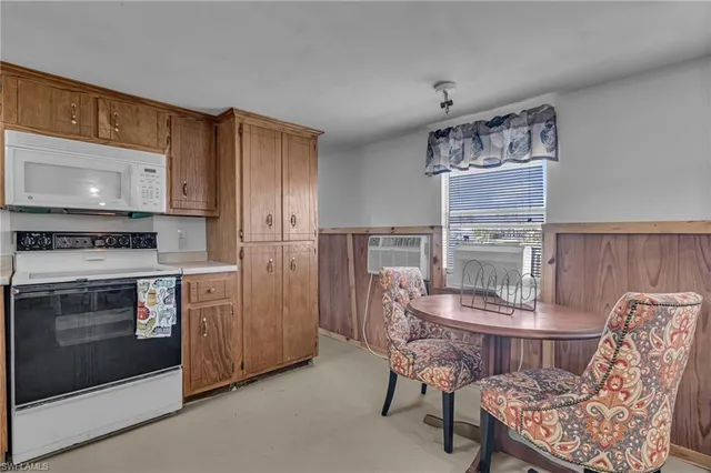 a kitchen with a stove and chairs