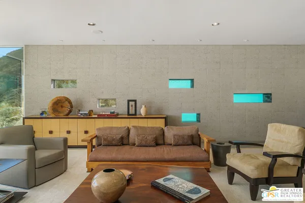 a living room with fireplace furniture and a large window
