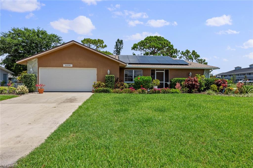 2219 Southeast 8th Street Cape Coral, FL 33990 - Photo 1 of 39 a front view of a house with a garden and plants